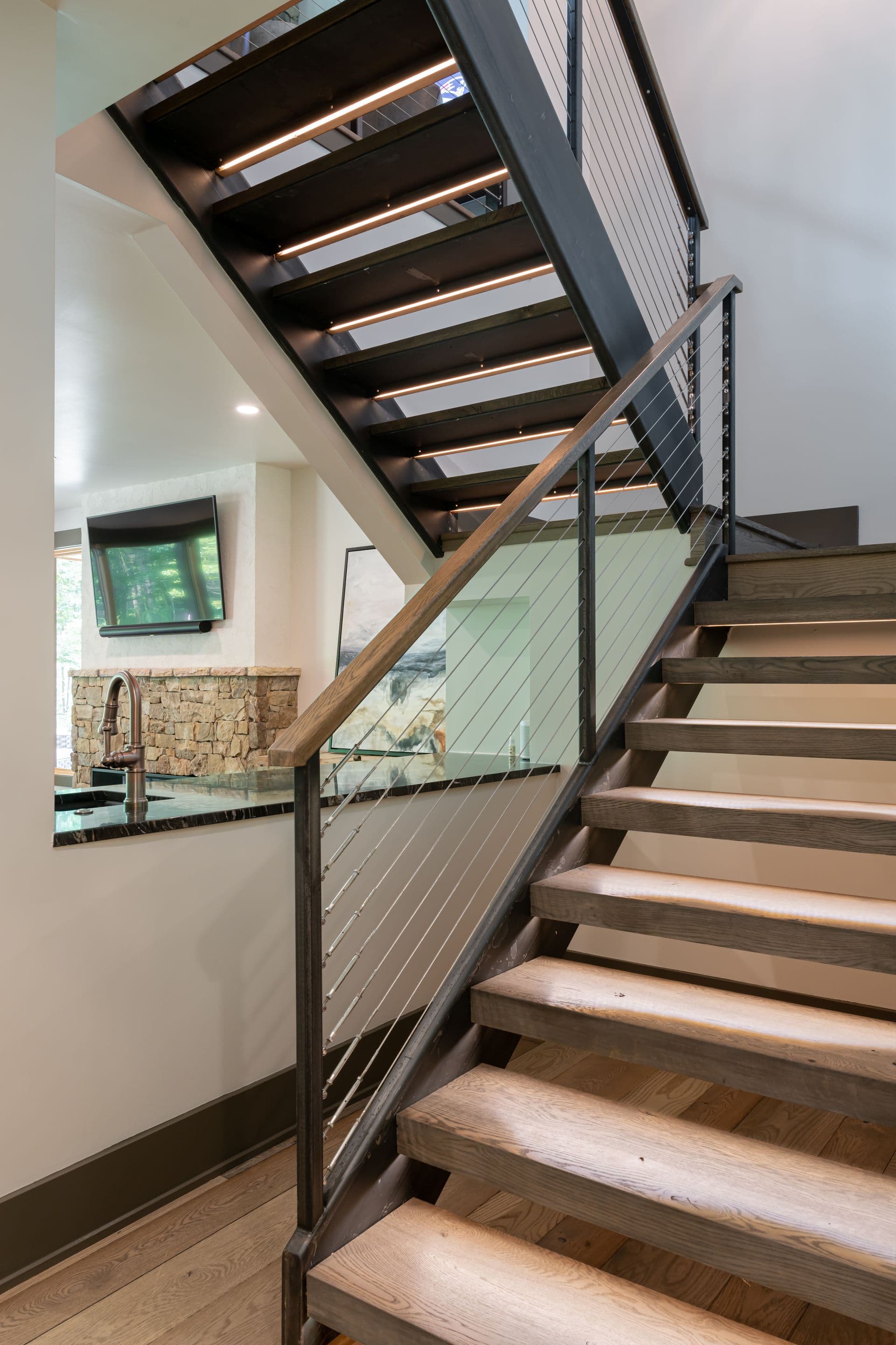 Floating wood staircase with dark metal railings