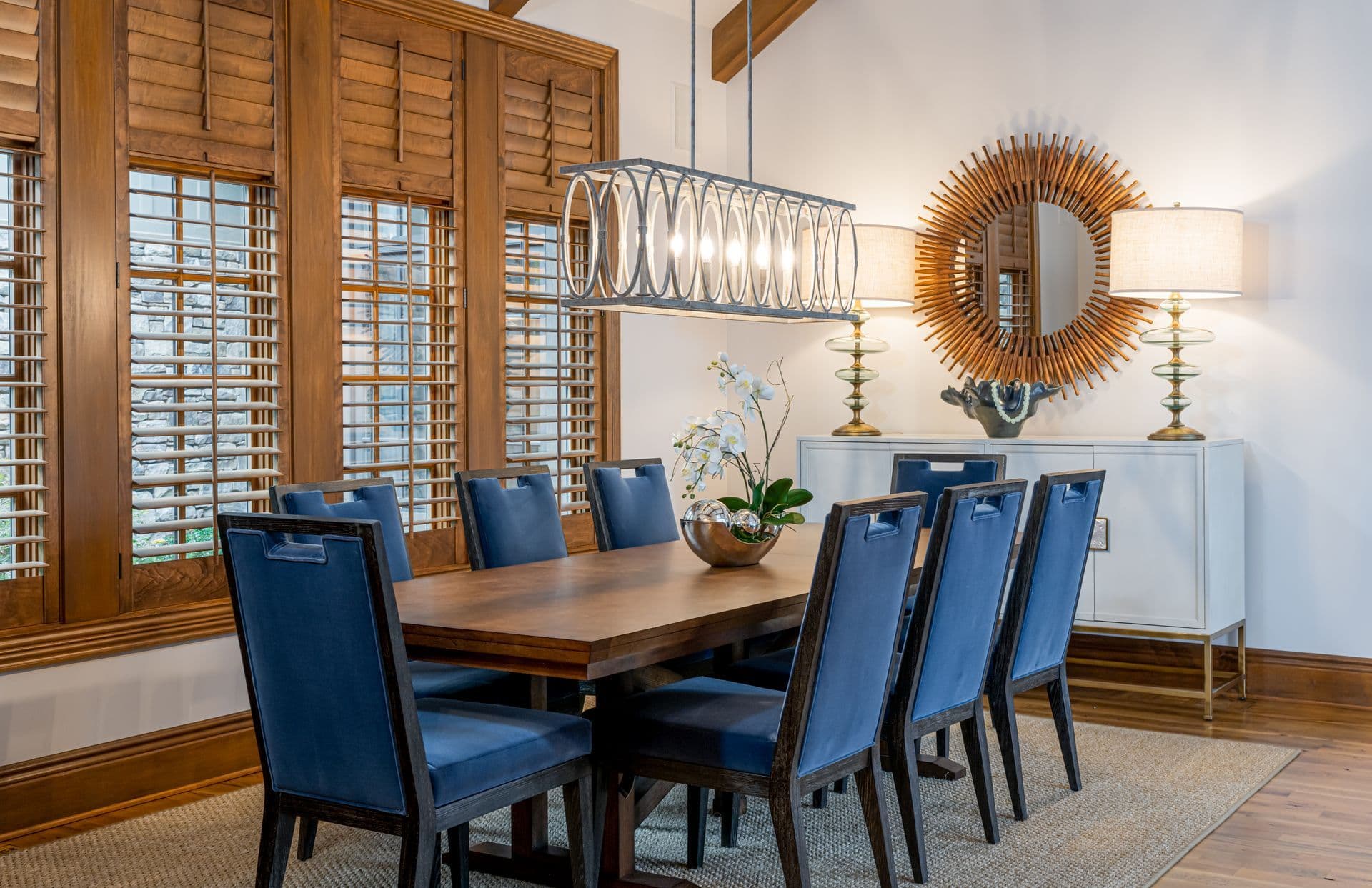 Dining room with a long table, blue chairs and warm wood details