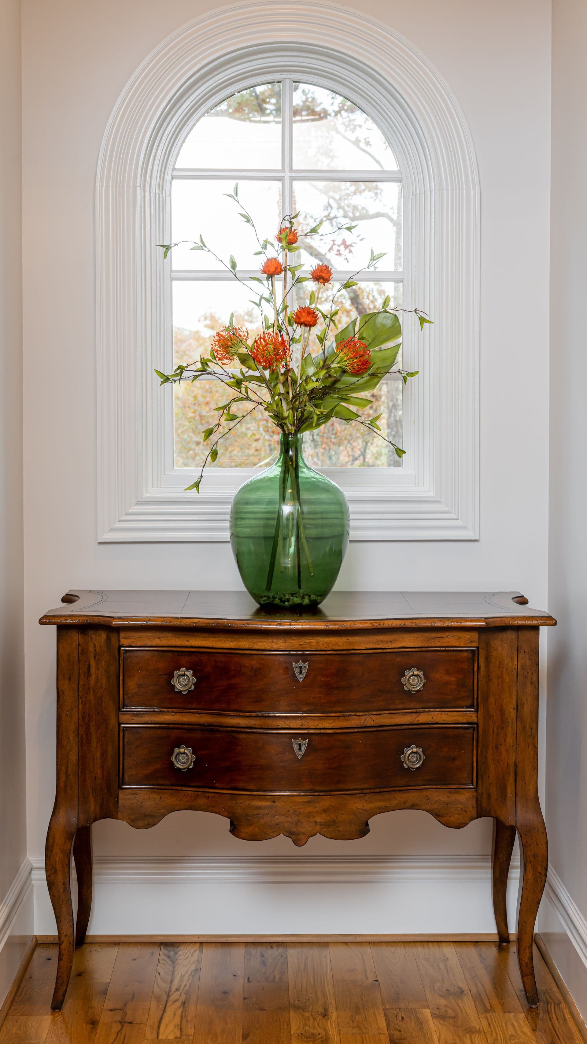 Vintage chest and fresh flowers beneath a bright window