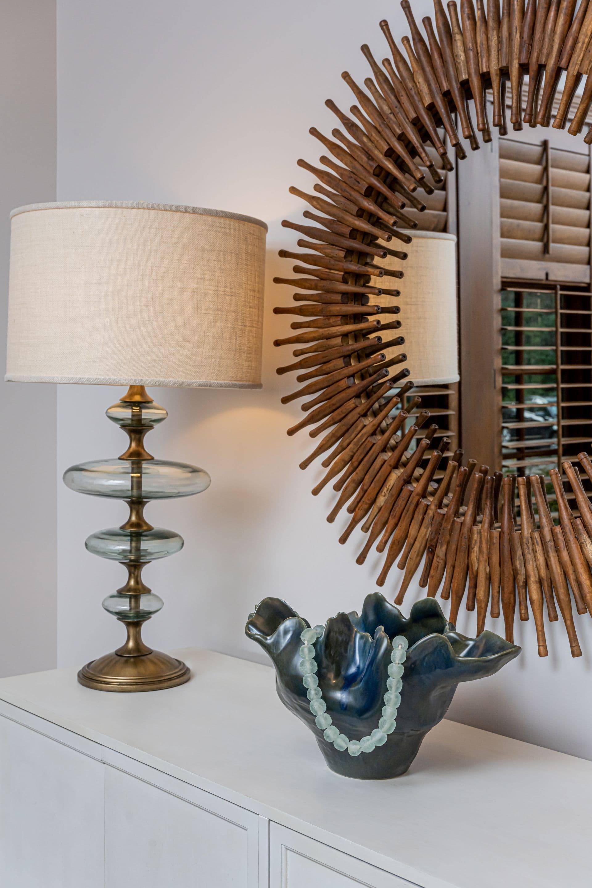 Sunburst mirror and collected accessories on a console