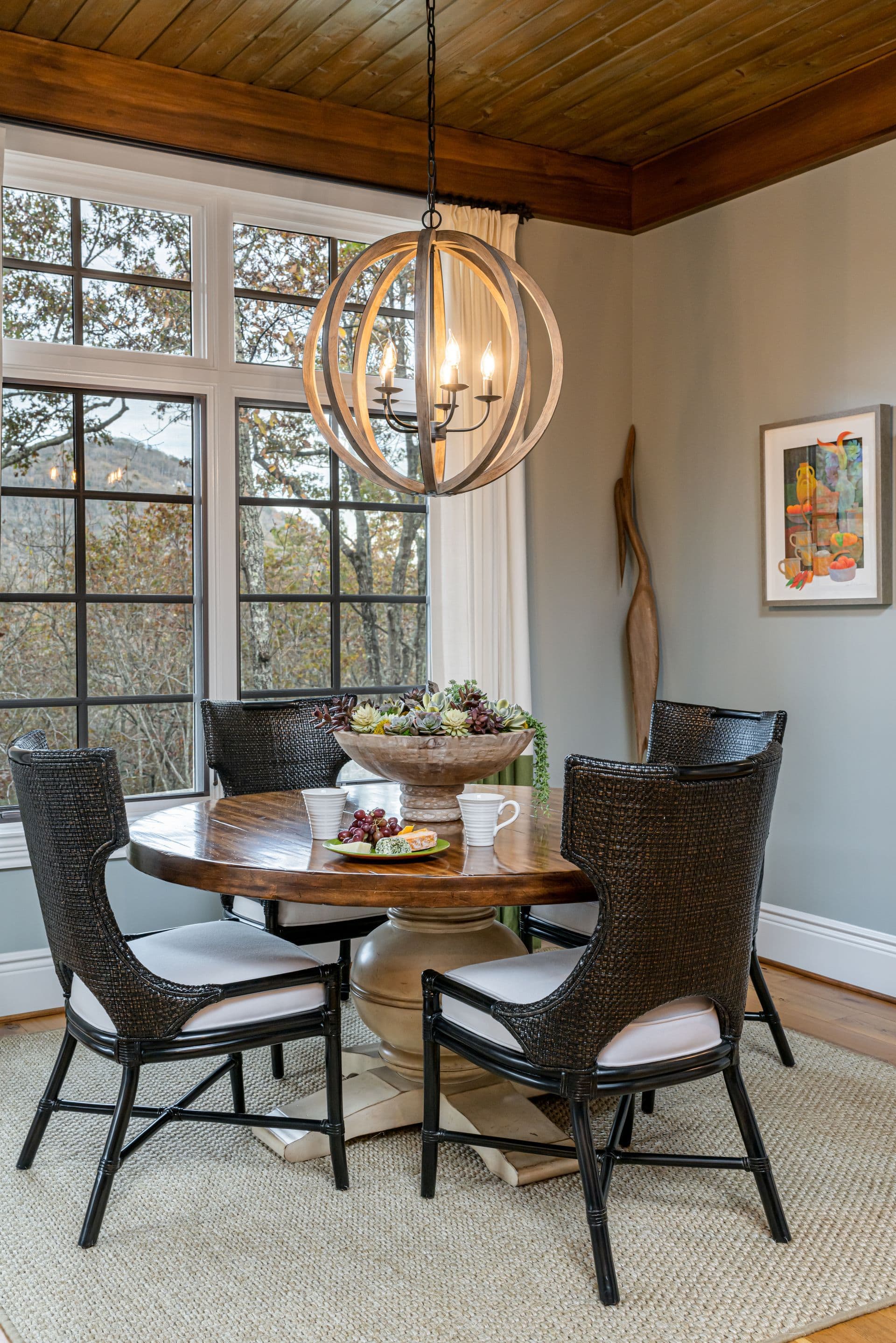 Dining nook with a natural wood ceiling and sculptural lighting